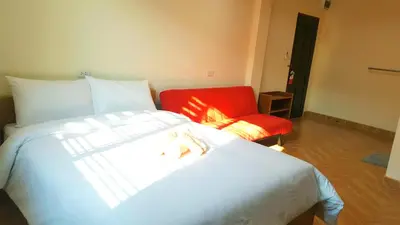 a bedroom with a bed and a red chair at Double D Rooms & Cafe in Bangkok