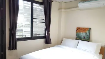 a bedroom with a bed and a window at Double D Rooms & Cafe in Bangkok