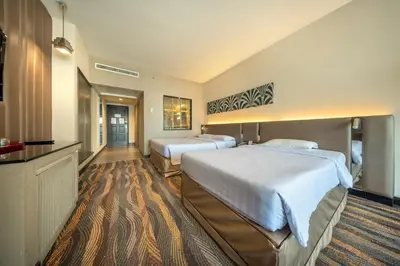 a hotel room with two beds and a television at Royal Benja Hotel - Big Rooms, Family Friendly in Bangkok