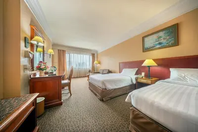 a hotel room with two beds and a desk at Royal Benja Hotel - Big Rooms, Family Friendly in Bangkok
