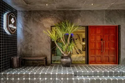 a vase with a plant sitting in front of a door at Sib Kao in Bangkok