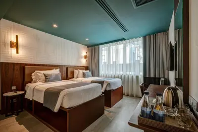 a hotel room with two beds and a table at Sib Kao in Bangkok