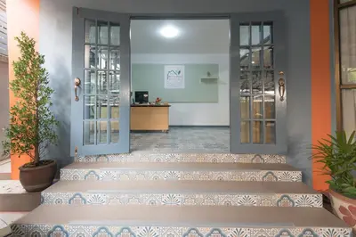 a set of stairs leading into a lobby with doors at BaanSu Hostel in Bangkok