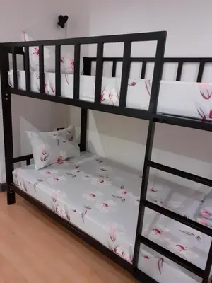 a black bunk bed with pink flowers on it at BaanSu Hostel in Bangkok