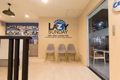 a sign for la sunbury with three stools in front of a store at Lazy Sunday hostel in Bangkok