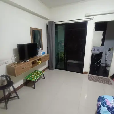 a living room with a tv and a large window at PA House Apartment in Bangkok
