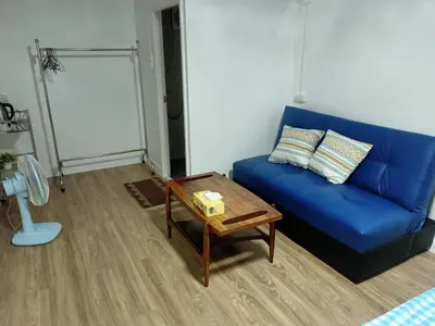 a blue couch in a living room with a table at PA House Apartment in Bangkok