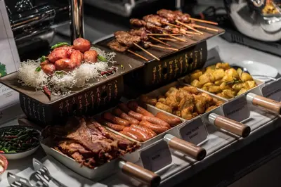 a buffet filled with different types of food in trays at MUU Bangkok, Small Luxury Hotels of the World in Bangkok