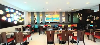 a dining room with tables and chairs in a restaurant at Nouvo City Hotel in Bangkok