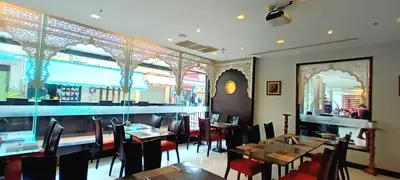 a restaurant with tables and chairs and a bar at Nouvo City Hotel in Bangkok