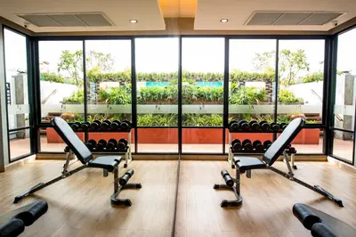 a gym with chairs and a large window at Nouvo City Hotel in Bangkok