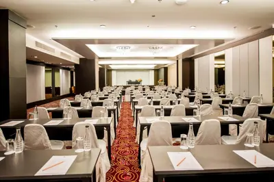 a large room with tables and white chairs at Nouvo City Hotel in Bangkok