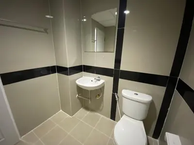 a bathroom with a toilet and a sink at Baansuay Rattanathibet Apartment in Nonthaburi