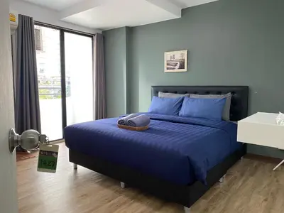 a bedroom with a blue bed with a hat on it at Baansuay Rattanathibet Apartment in Nonthaburi