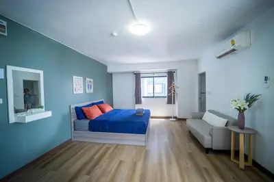 a blue bedroom with a bed and a couch at Baansuay Rattanathibet Apartment in Nonthaburi