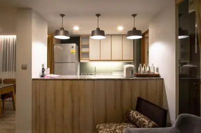 a kitchen with a counter with a refrigerator at The Residence Rajtaevee Hotel in Bangkok