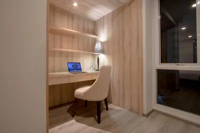 a room with a desk with a chair and a laptop at The Residence Rajtaevee Hotel in Bangkok