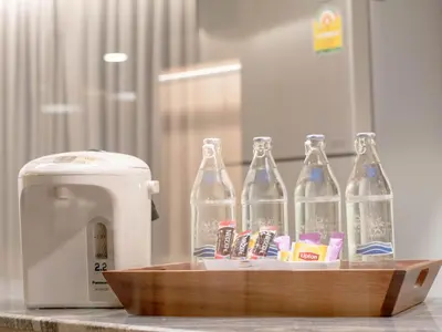 a wooden tray with four soda bottles on a counter at The Residence Rajtaevee Hotel in Bangkok