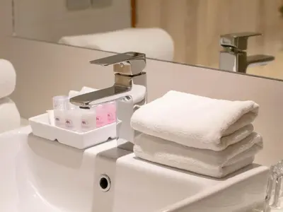 a pile of towels sitting on top of a bathroom sink at The Residence Rajtaevee Hotel in Bangkok