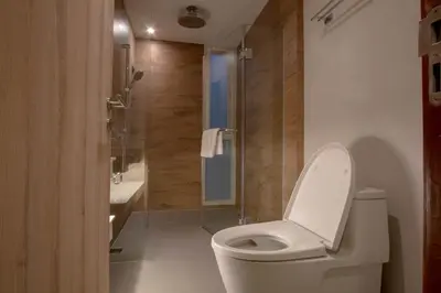a bathroom with a toilet and a shower and a sink at The Residence Rajtaevee Hotel in Bangkok
