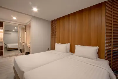 a bedroom with two large white beds in it at The Residence Rajtaevee Hotel in Bangkok
