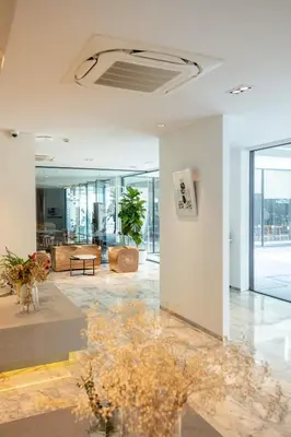 a large room with a lobby with tables and chairs at Reno hotel in Bangkok