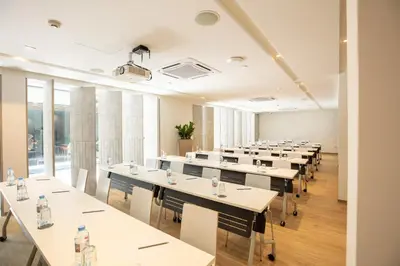 a row of tables in a room with windows at Reno hotel in Bangkok
