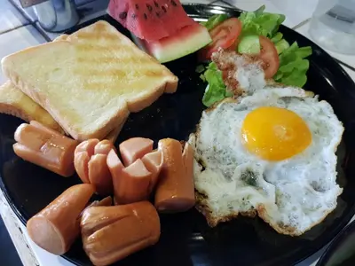 a plate of breakfast food with eggs bread and toast at Pastelhouse hostel in Bangkok