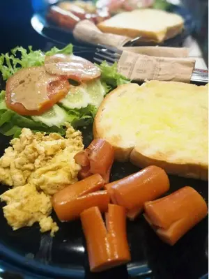 a plate of food with carrots and bread and vegetables at Pastelhouse hostel in Bangkok