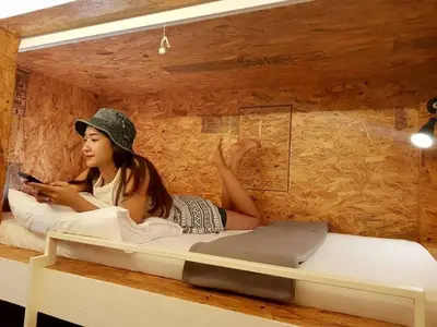 a girl laying on a bed in a room at Pastelhouse hostel in Bangkok