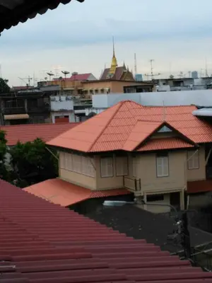 a building with an orange roof on top of a city at Home & Hashery Boutique House in Bangkok