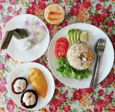 three plates of food on a table with flowers at Home & Hashery Boutique House in Bangkok
