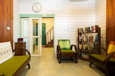 a room with two chairs and a clock on the wall at Home & Hashery Boutique House in Bangkok