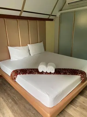 a bed with two towels on top of it at Kurina Hotel in Bangkok