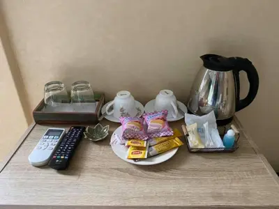 a table with a coffee pot and a remote control at Kurina Hotel in Bangkok