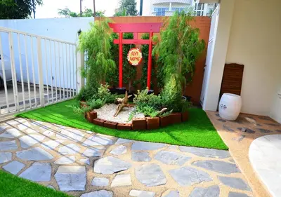 a patio with a garden with grass and plants at Ayi Home in Bangkok