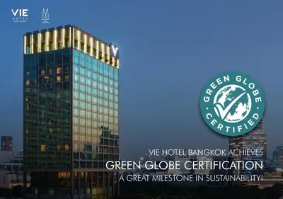 a green glass building with a green circle on it at VIE Hotel Bangkok - MGallery Collection in Bangkok