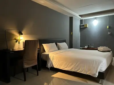 a hotel room with a bed and a desk and a bed sidx sidx at Centric Place Hotel in Bangkok
