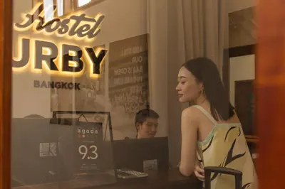 a woman standing in front of a store window at Hostel Urby in Bangkok