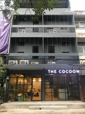 a building with a sign that reads the coop at The Cocoon Hostel in Bangkok