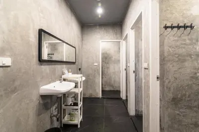 a bathroom with a sink and a mirror at The Cocoon Hostel in Bangkok