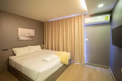 a bedroom with a bed and a television in it at Dazzle Residence in Bangkok