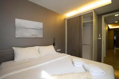 a bedroom with a large bed with white pillows at Dazzle Residence in Bangkok