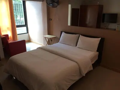 a bedroom with a large bed with white sheets and pillows at Chanmuan Resident in Bangkok
