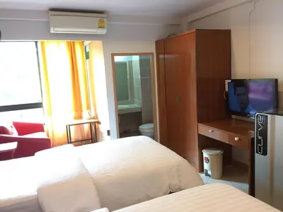a bedroom with a bed and a flat screen tv at Chanmuan Resident in Bangkok