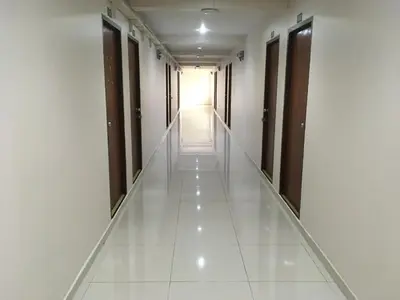 an empty corridor of an office building with white tiles at Chanmuan Resident in Bangkok