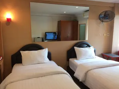 two beds sitting next to each other in a room at Chanmuan Resident in Bangkok