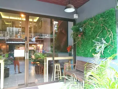 a restaurant with a bench in front of a window at Phobphan Hostel in Bangkok