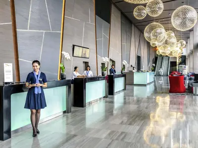 a woman standing in the lobby of a hotel at Novotel Bangkok IMPACT in Nonthaburi