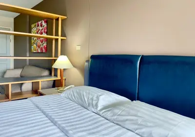a bed with a blue head board in a room at BU Place Hotel in Bangkok